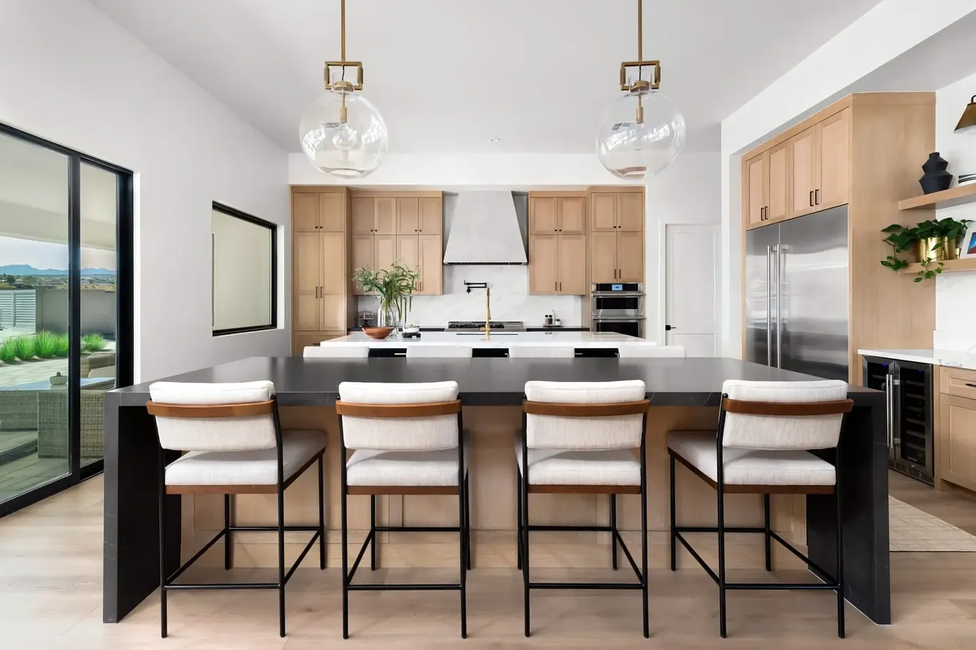 Your custom kitchen, designed around your home Wood kitchen island with upholstered stools and white perimeter cabinets